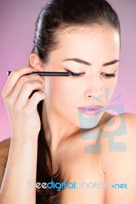 Woman Applying Cosmetic Pencil Stock Photo