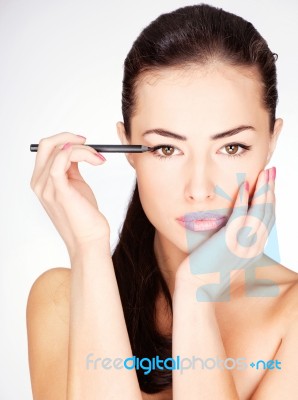 Woman Applying Cosmetic Pencil Stock Photo