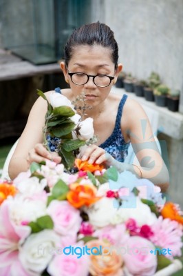 Woman Arranging Artificial Flower In Wood Box Stock Photo