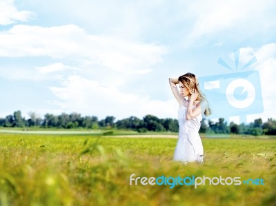 Woman At Wheat Field On Sunny Day Stock Photo