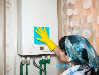 Woman Cleaning A Boiler With A Rag Stock Photo