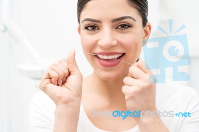 Woman Cleaning Her Teeth By Dental Floss Stock Photo