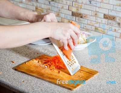 Woman Cooks The Carrot On A Grater Stock Photo