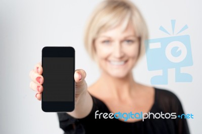 Woman Displaying New Phone In Market Stock Photo