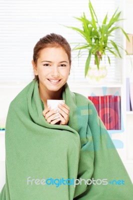 Woman Drinking Tea  At Home Covered With Blanket Stock Photo