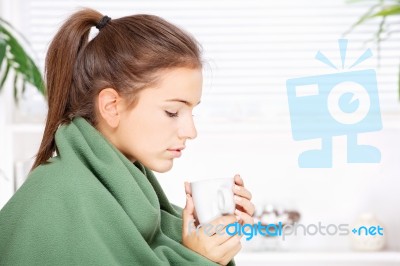 Woman Drinking Tea  At Home Covered With Blanket Stock Photo