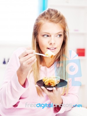 Woman Eating Cake At Home Stock Photo