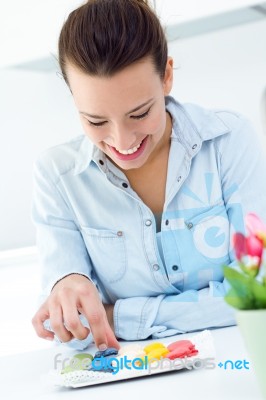 Woman Eating French Cookies At Home Stock Photo