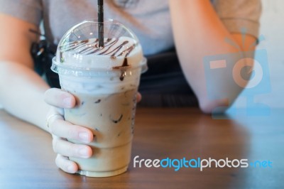 Woman Hand On Iced Milk Coffee Drink Stock Photo