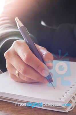 Woman Hand With Pen Writing On Notebook Stock Photo