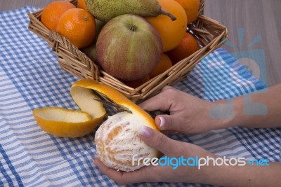 Woman Hands Peeling An Orange With A Knife Stock Photo