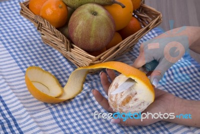 Woman Hands Peeling An Orange With A Knife Stock Photo