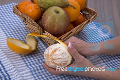 Woman Hands Peeling An Orange With A Knife Stock Photo