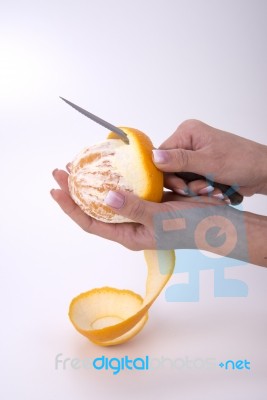 Woman Hands Peeling An Orange With A Knife Stock Photo