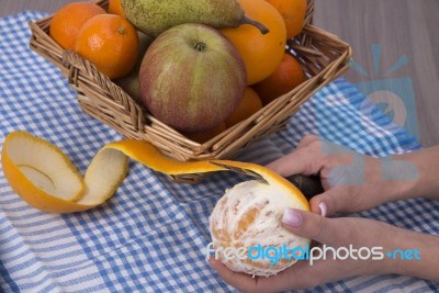 Woman Hands Peeling An Orange With A Knife Stock Photo