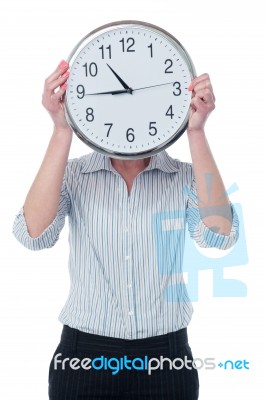 Woman Hiding Her Face Behind Wall Clock Stock Photo