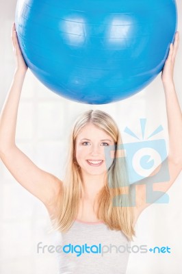 Woman Holding Pilates Ball Over Her Head Stock Photo