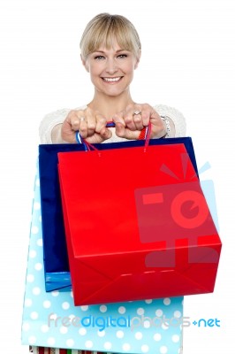 Woman Holding Shopping Bags In Her Outstretched Arms Stock Photo