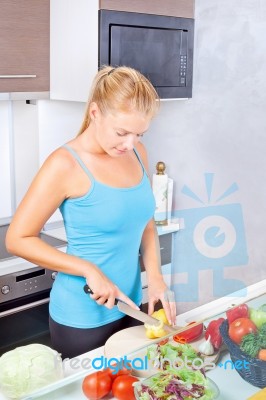 Woman In Kitchen Cutting Vegetables Stock Photo