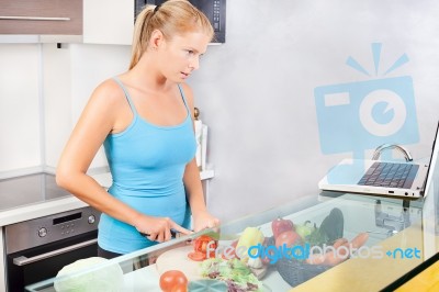 Woman In Kitchen With Laptop Stock Photo