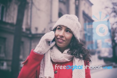 Woman In Red Coat And Wool Cap And Gloves With Smartphone Stock Photo