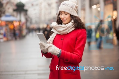 Woman In Red Coat And Wool Cap And Gloves With Smartphone In Han… Stock Photo