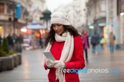 Woman In Red Coat And Wool Cap And Gloves With Smartphone In Han… Stock Photo