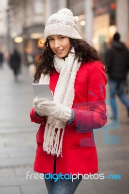 Woman In Red Coat And Wool Cap And Gloves With Smartphone In Han… Stock Photo