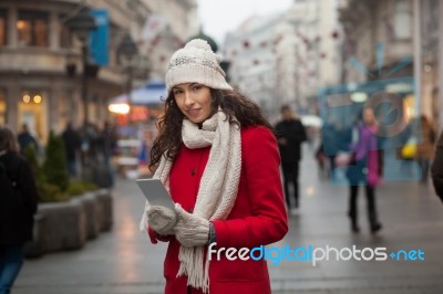 Woman In Red Coat And Wool Cap And Gloves With Smartphone In Han… Stock Photo