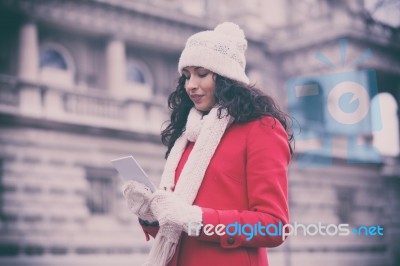 Woman In Red Coat And Wool Cap And Gloves With Smartphone In Han… Stock Photo