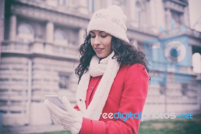 Woman In Red Coat And Wool Cap And Gloves With Smartphone In Han… Stock Photo