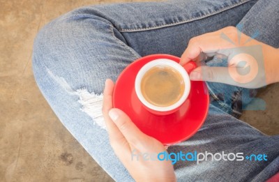 Woman In Torn Jeans Sitting At Coffee Shop Stock Photo