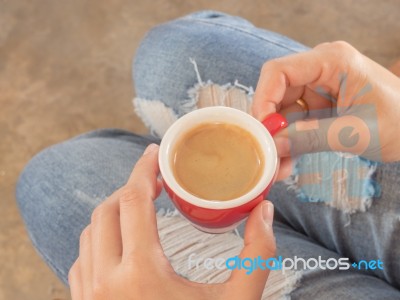 Woman In Torn Jeans Sitting At Coffee Shop Stock Photo