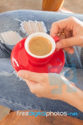 Woman In Torn Jeans Sitting At Coffee Shop Stock Photo