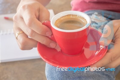 Woman In Torn Jeans Sitting At Coffee Shop Stock Photo