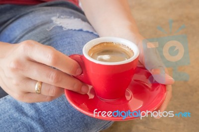 Woman In Torn Jeans Sitting At Coffee Shop Stock Photo