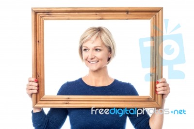 Woman Looking Away From Behind A Frame Stock Photo