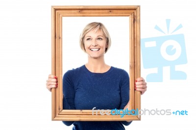 Woman Looking Through Wooden Frame Stock Photo