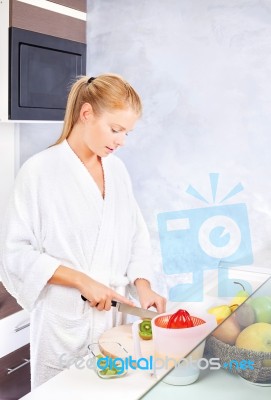 Woman Making Fruit Salad In Kitchen Stock Photo