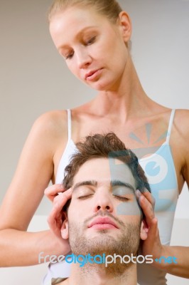 Woman Massaging Mans Temples Stock Photo