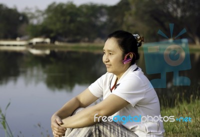 Woman On Grass Listening To Music Stock Photo