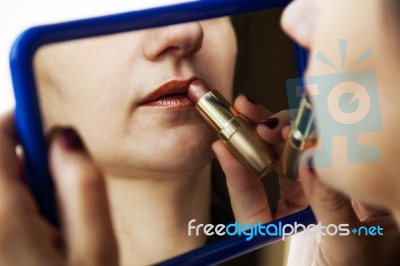 Woman Paints Lips With Lipstick Before A Mirror Stock Photo