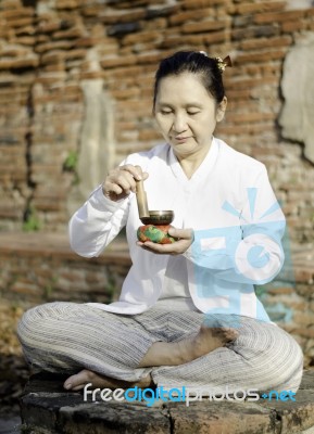 Woman Playing A Tibetan Bowl, Traditionally Used To Aid Meditati… Stock Photo