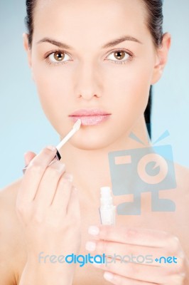 Woman Putting Lipstick On Her Lips Stock Photo