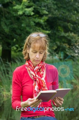 Woman Reading Book In Nature Stock Photo