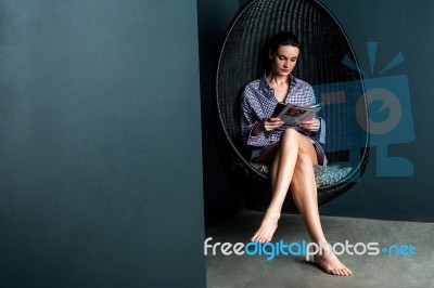 Woman Reading Magazine, Sitting On Swinging Chair Stock Photo