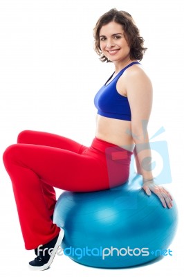 Woman Relaxing On Big Exercise Ball After Workout Stock Photo