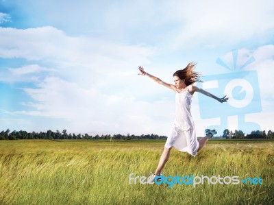 Woman Running Across Field Stock Photo