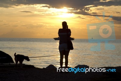 Woman Shooting With Camera At Sunset Stock Photo