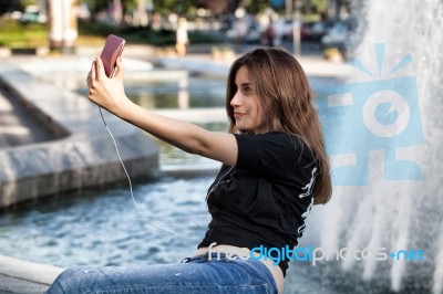 Woman Sitting  And Making Selfie Stock Photo